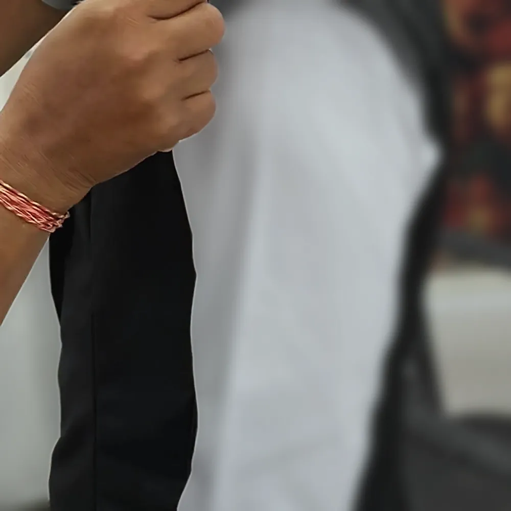 The fit at the waist being checked by hand on a black jacket worn over a white shirt