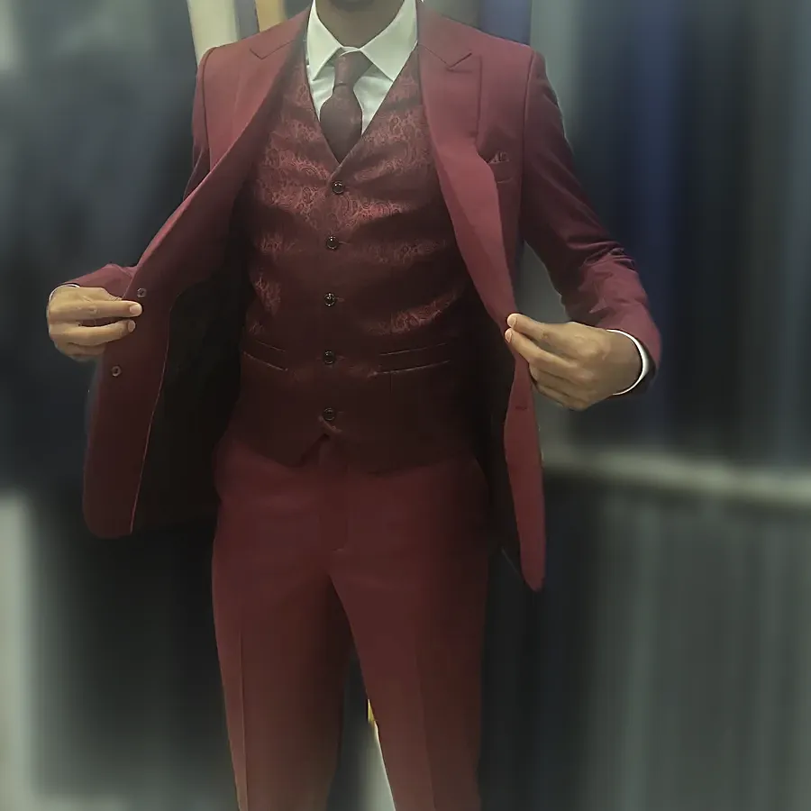 A client opening a burgundy three-piece jacket to show the waistcoat, in the shop — from Colin W's review