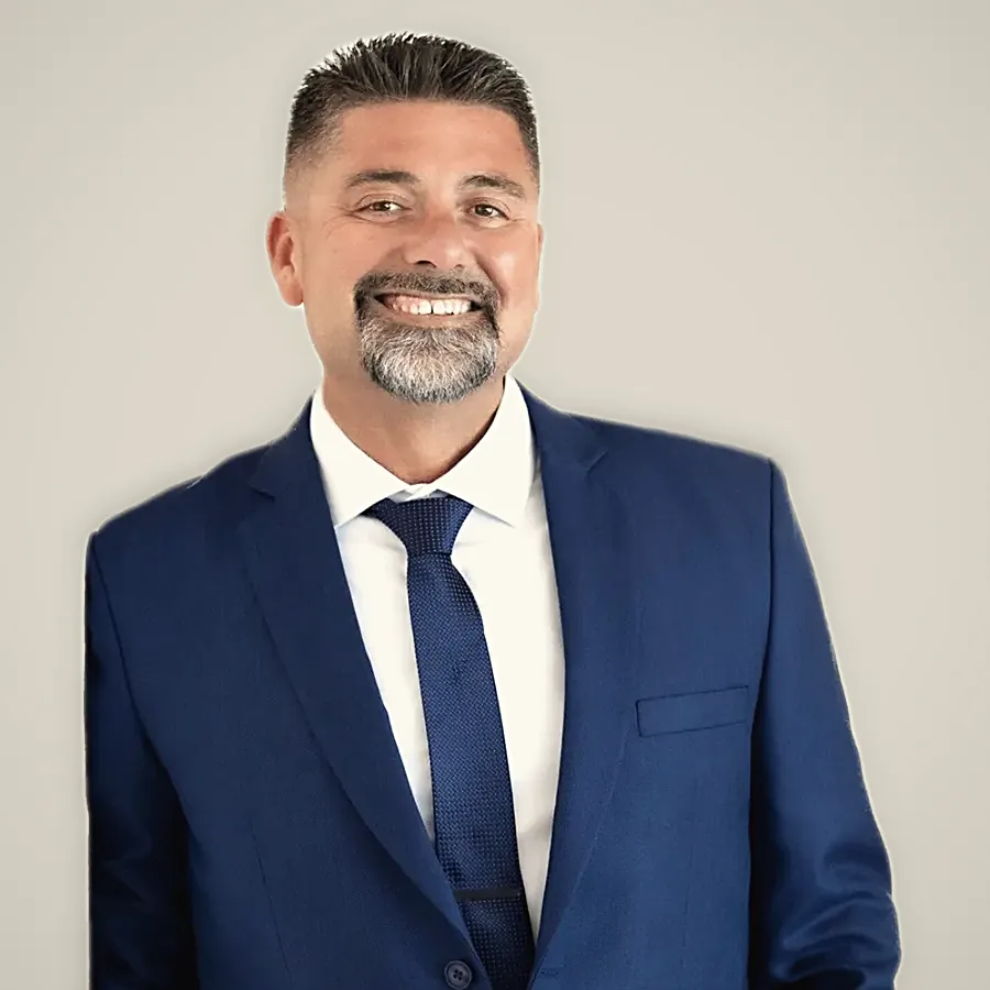 A client in a navy suit, white shirt and navy tie, smiling — from Sean Farley's review
